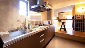 A modern kitchen with a stainless steel sink, a microwave, and a stove. - SEVENSTORIES (Nagoya)