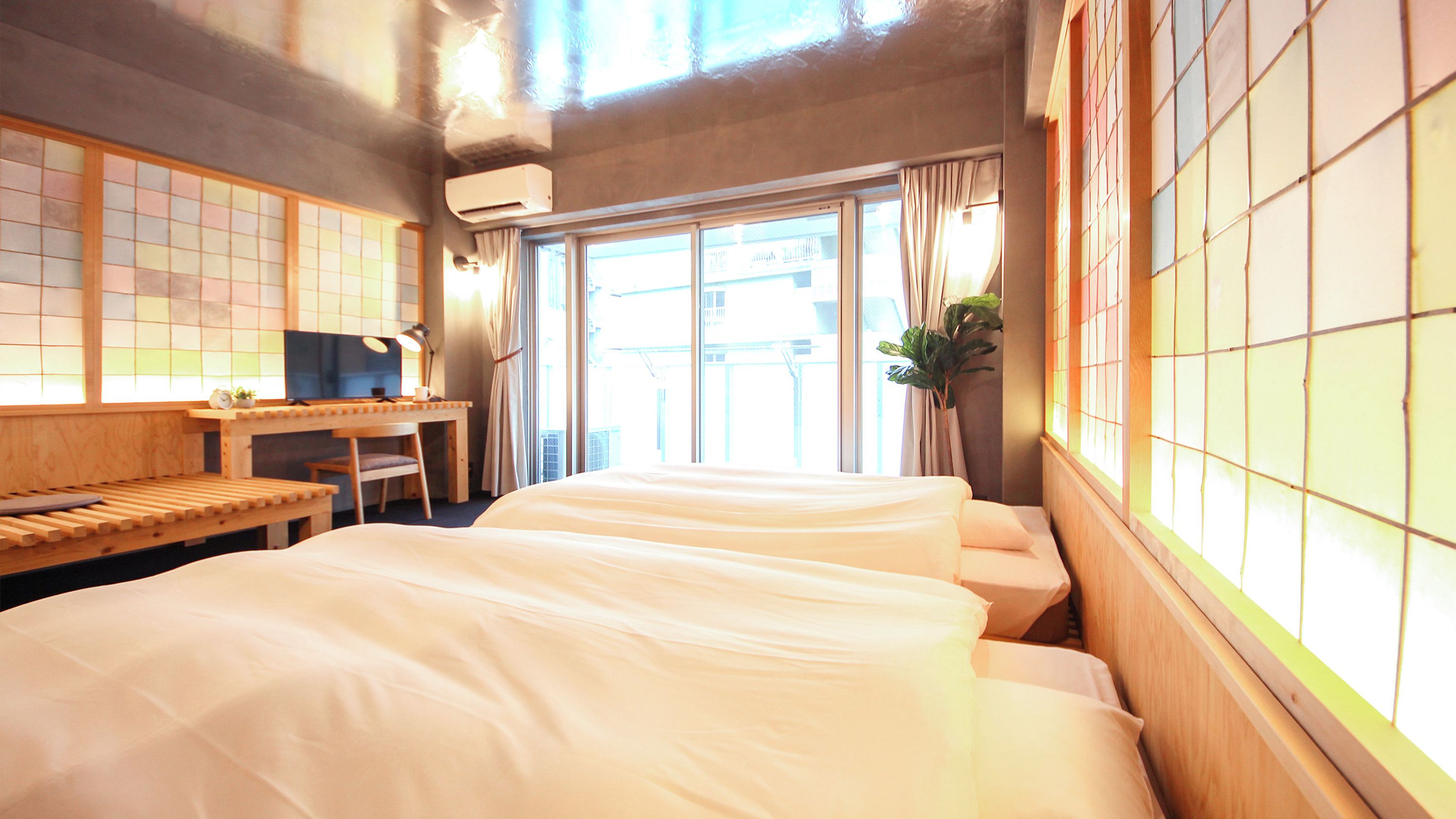 Una camera d'albergo con un letto, una scrivania, una sedia e una finestra.