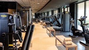 A gym with various exercise machines, treadmills, and benches.