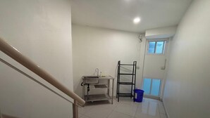A small, clean bathroom with a sink, a mirror, and a window. - NamasStay Silom (Bangkok)