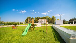 Un parque infantil con tobogán, columpios y estructura para escalar.