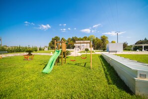 A playground with a slide, swings, and a climbing structure. - Dimora Cristal With Pool And Padel, Galatina, Italy (Galatina)
