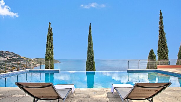 A pool with lounge chairs, a clear sky, and a view of the sea. - Apartment Sea View Panorama, Roquebrune-Cap-Martin, France (Roquebrune-Cap-Martin)