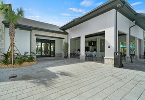 Un bâtiment moderne doté d’un patio, d’un espace extérieur aménagé et d’un palmier.
