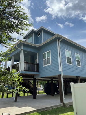 A two-story house with a balcony, a garage, and a covered outdoor area. - KEMAH BREEZE - Walking Distance to Kemah Boardwalk, Restaurants, Shops, (Kemah)