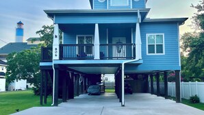 A two-story house with a covered porch and a driveway leading to the front door.