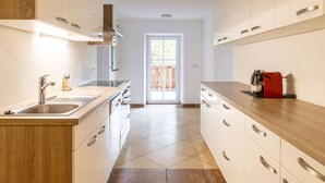 Una cocina moderna con una isla central, pileta de acero inoxidable y muebles de madera.