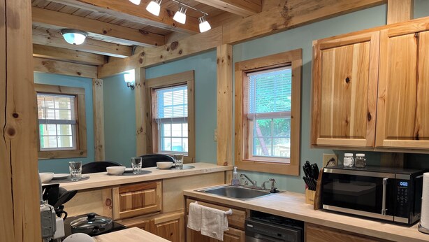 A modern kitchen with wooden cabinets, a stainless steel sink, a microwave, and a dishwasher.