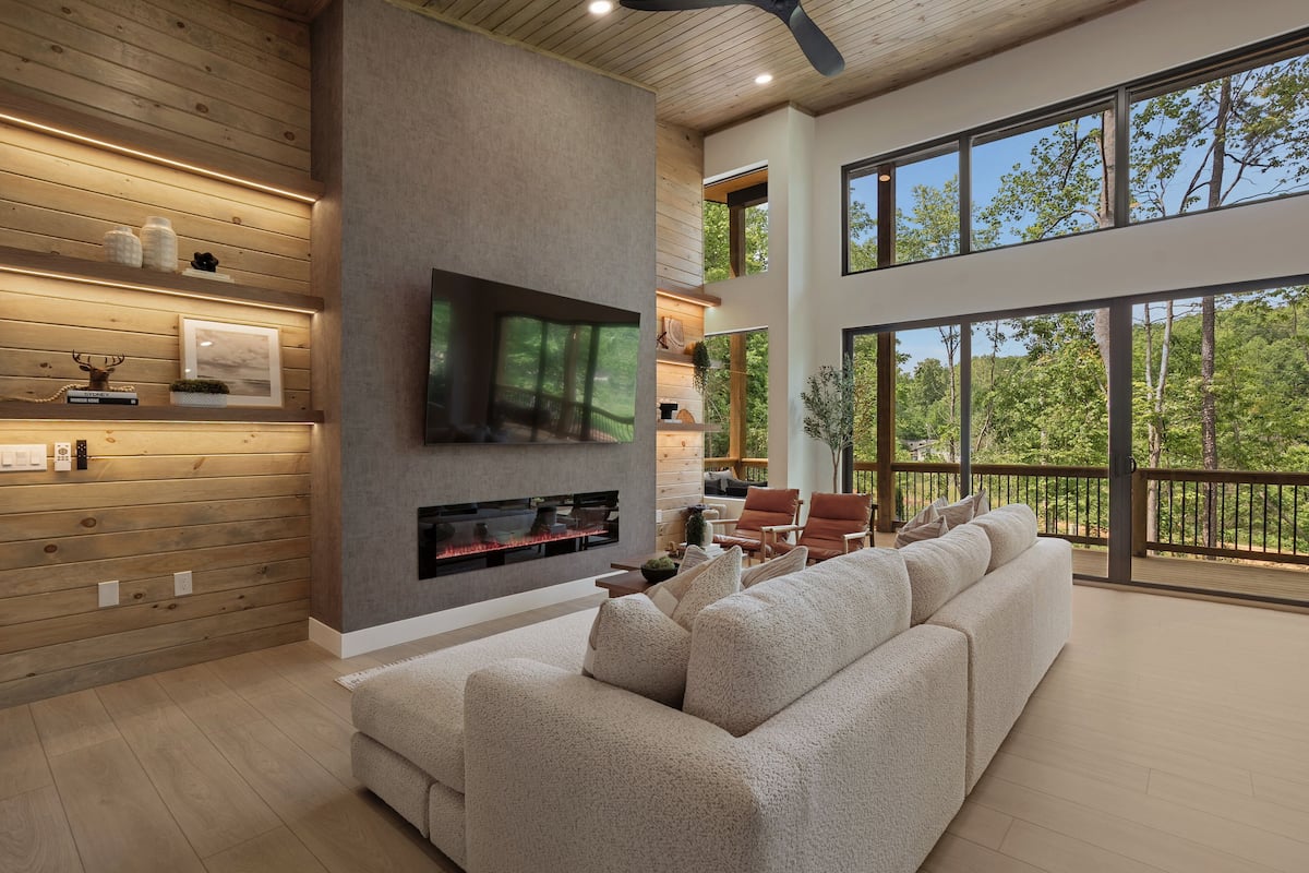 Una sala de estar moderna con un televisor grande, chimenea y sofá.