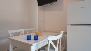 A white table with two chairs, a basket, and two blue glasses. - GuestHost - Cozy Flat in the Heart of Letojanni (Letojanni)