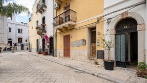 A quiet street with buildings, a motorcycle, and a potted plant. - GuestHost - Cozy Flat in the Heart of Letojanni (Letojanni)