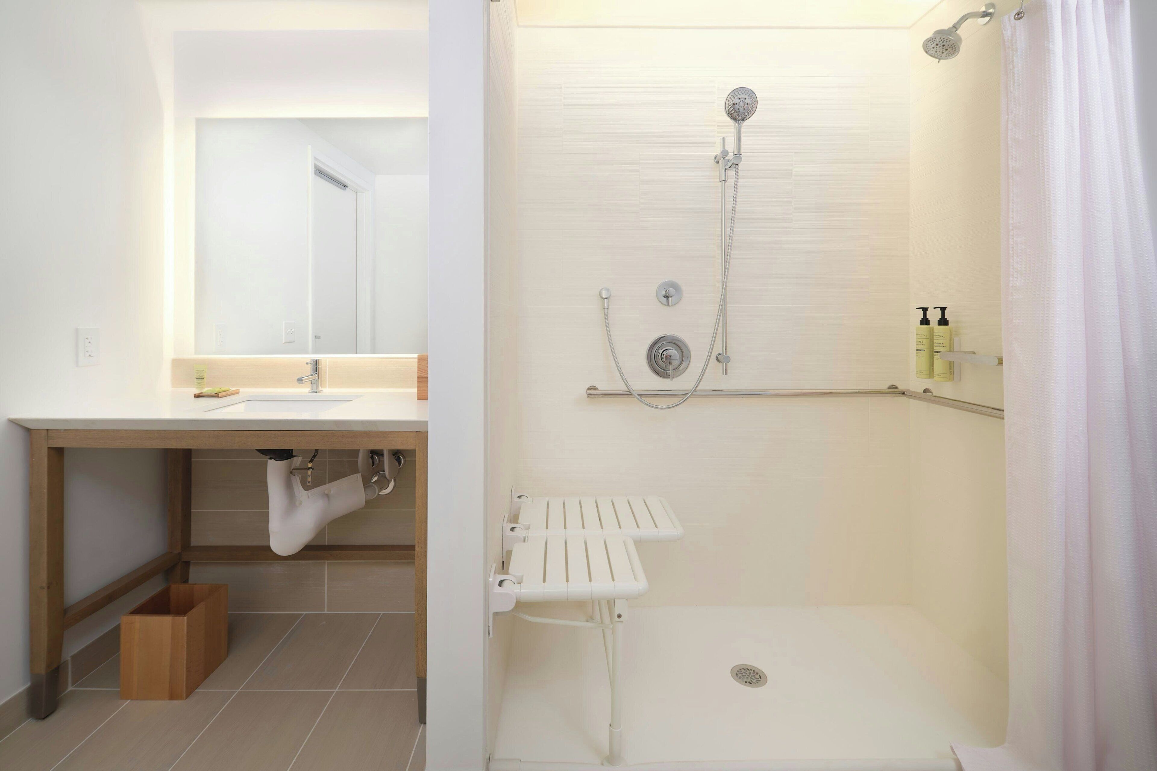 Un baño moderno con lavamanos, espejo, ducha y estante para almacenamiento.
