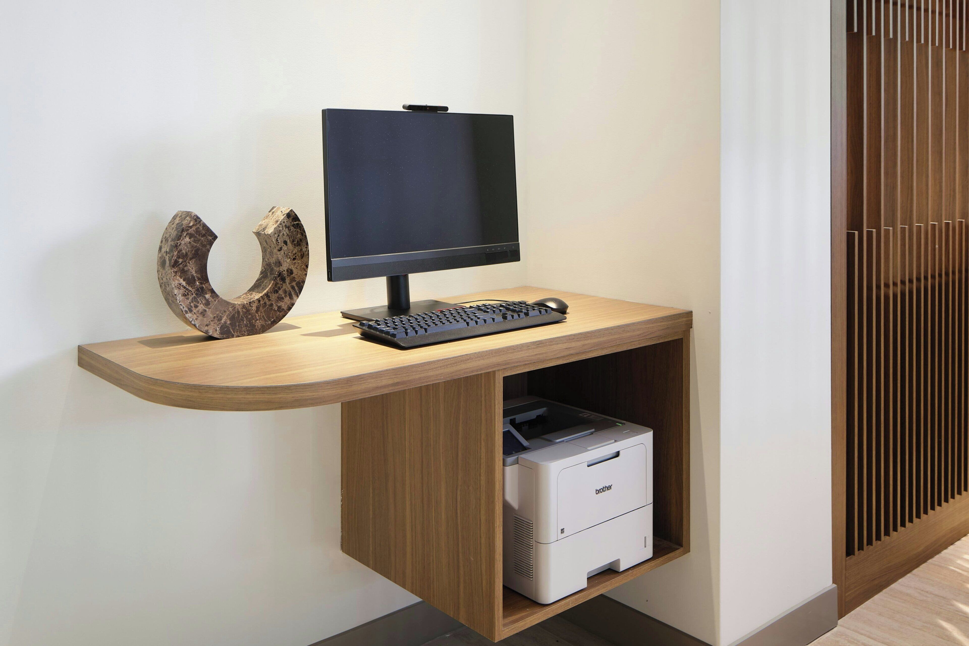 Een modern bureau met een monitor, toetsenbord en printer.