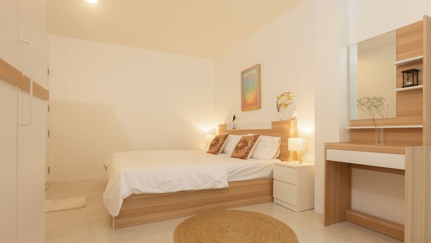 A bedroom with a bed, bedside table, lamp, and a mirror. - PLACE HOTEL (Karon)