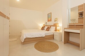 A bedroom with a bed, bedside table, lamp, and a mirror. - PLACE HOTEL (Karon)