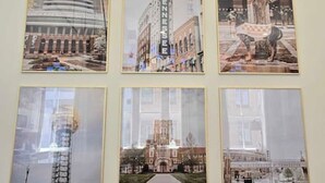 Six photographies encadrées représentant des bâtiments, accrochées à un mur.