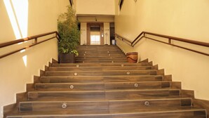 Una scala in legno con corrimano che conduce a un ascensore.