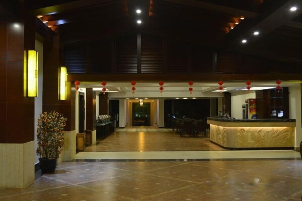 A spacious lobby with a reception desk, seating area, and a large potted plant. - Wanning Mantening Wenquan Serviced Apartment (Xinglong Town) (Wanning)