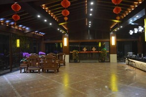 A spacious lobby with a reception desk, seating area, and decorative elements like hanging lanterns. - Wanning Mantening Wenquan Serviced Apartment (Xinglong Town) (Wanning)