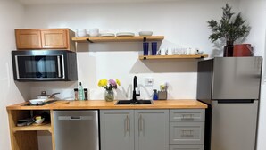 A compact kitchen with a microwave, refrigerator, wooden countertop, and built-in cabinets. - Cozy casita nestled in Laketree Estates, 5 min walk to Monserate Winery. (Fallbrook)