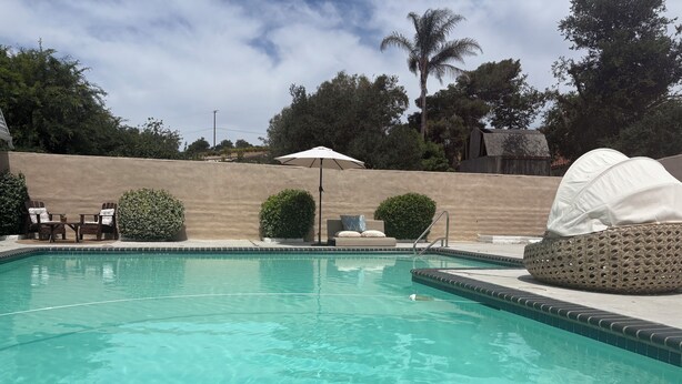 A clear swimming pool with lounge chairs and a sun umbrella. - Cozy casita nestled in Laketree Estates, 5 min walk to Monserate Winery. (Fallbrook)