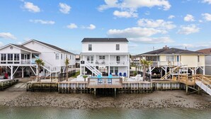 A beachfront property with multiple buildings, a dock, and a pool area.