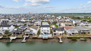 A coastal residential area with houses, a dock, and a swimming pool.