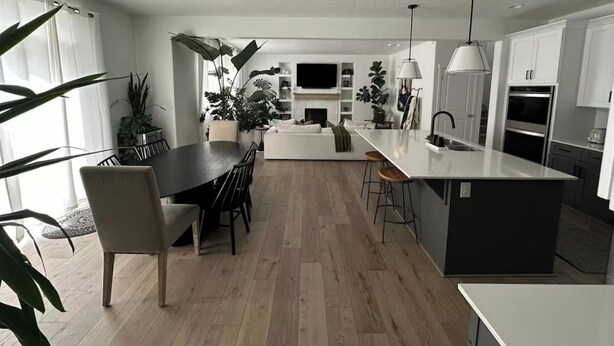 Una cocina moderna con una isla central, comedor y asientos de bar.