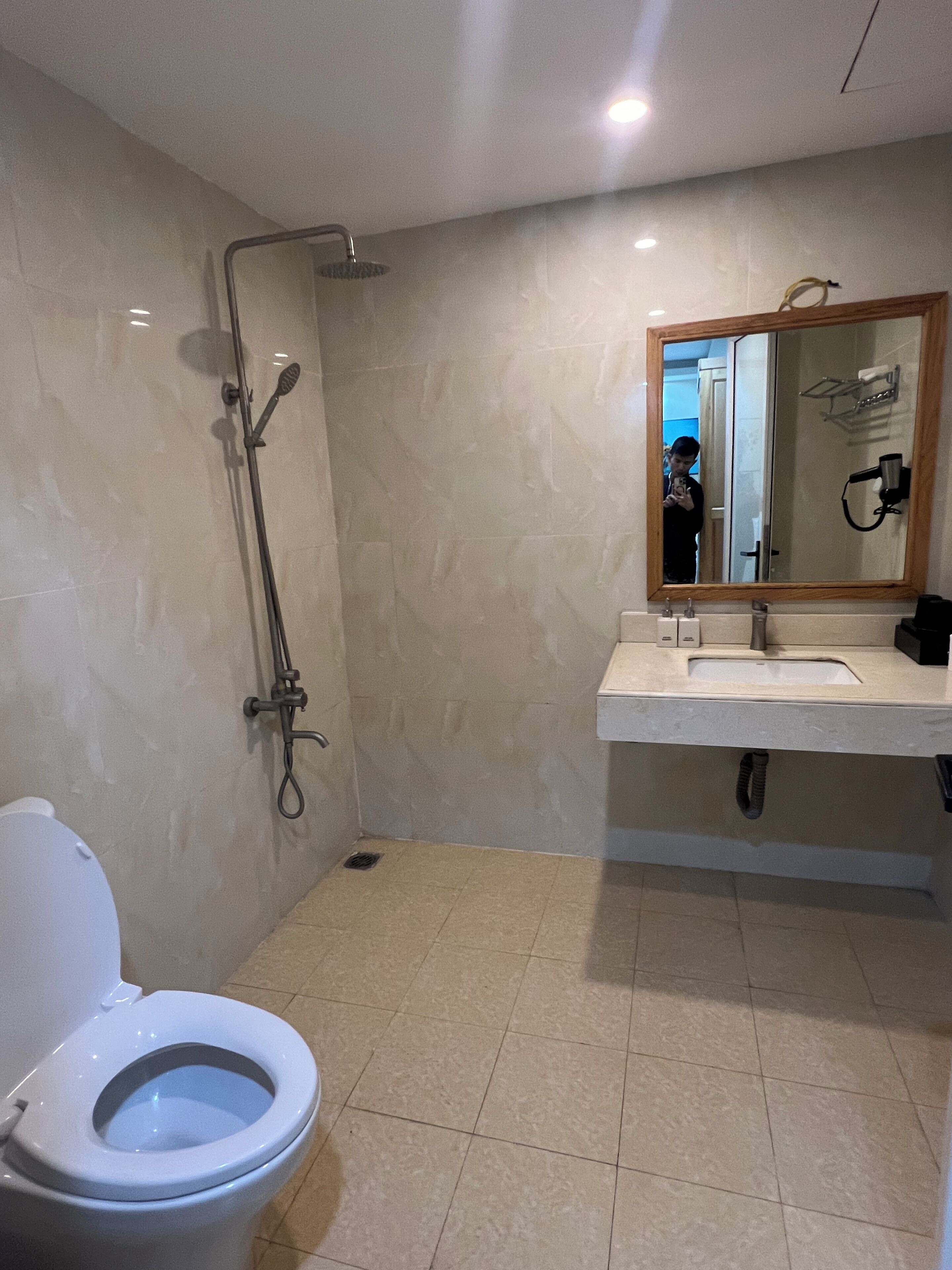 Un bagno con toilette, doccia e lavandino con specchio.