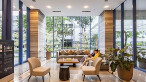 Een moderne lobby met een bank, stoelen en potplanten.