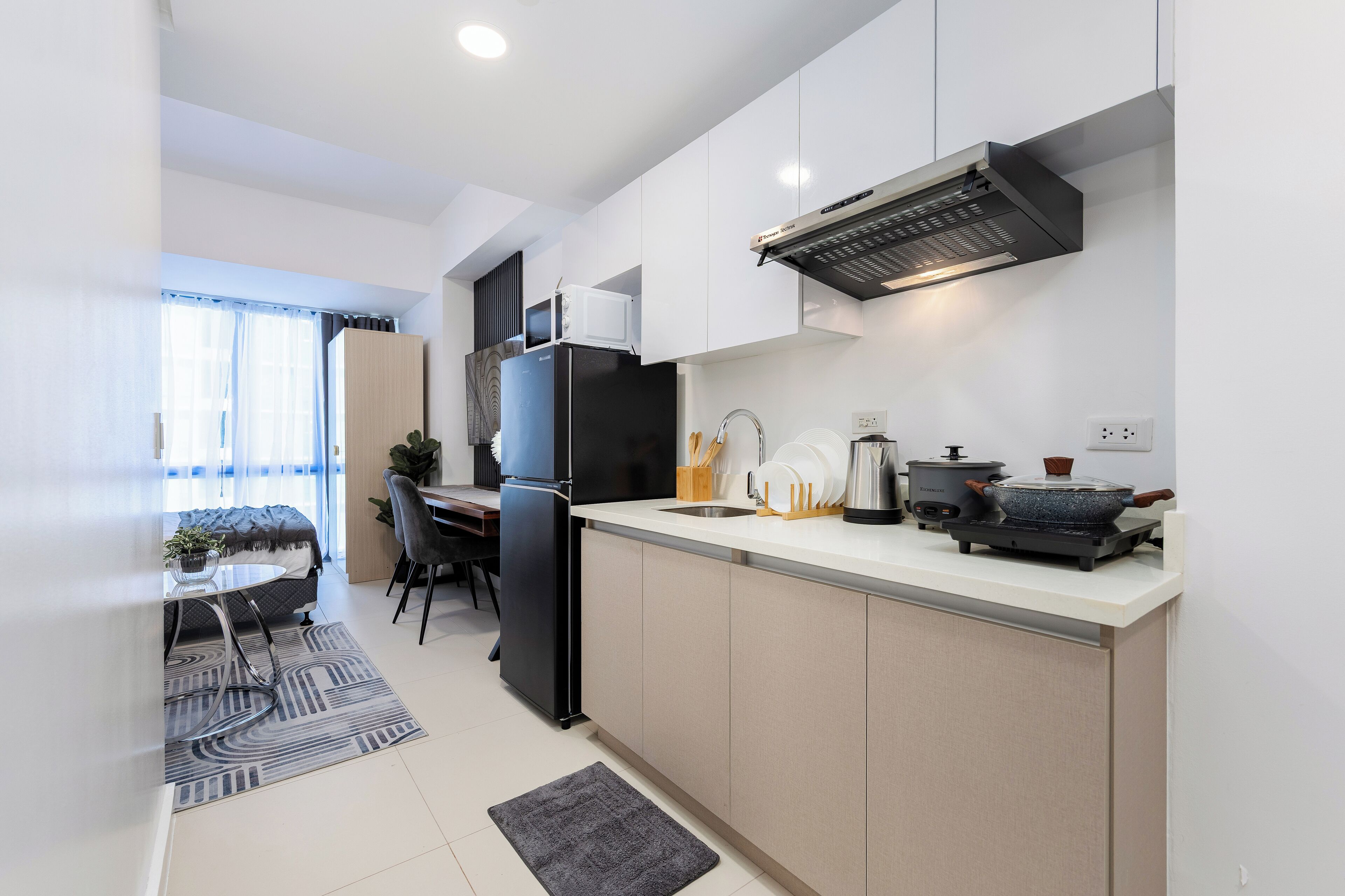 Una cocina moderna con refrigerador, estufa, pileta y alacenas.