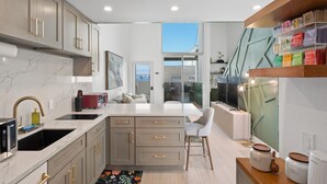 Una cocina moderna con encimeras de mármol, una isla integrada y vistas a la ciudad.