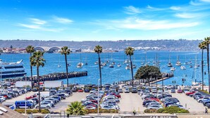 Un puerto deportivo con numerosos barcos y un estacionamiento lleno de coches.