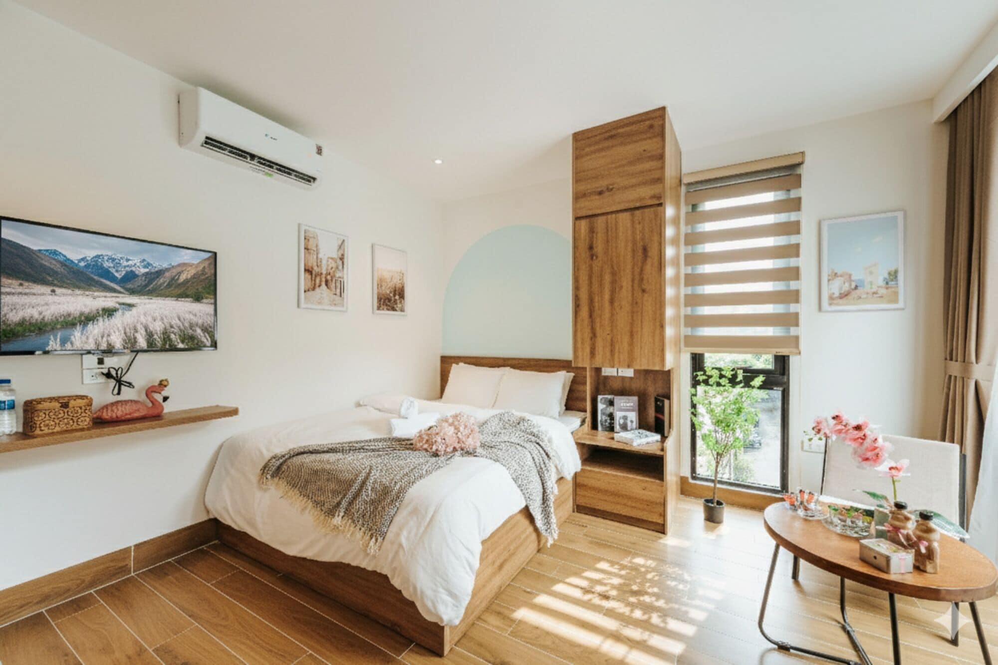 Quarto moderno com cama de madeira, televisão e janela com persianas.