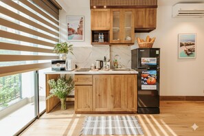 Estúdio júnior, vista para o pátio | Cozinha privada | Geladeira grande, cooktop, talheres/pratos/utensílios de cozinha