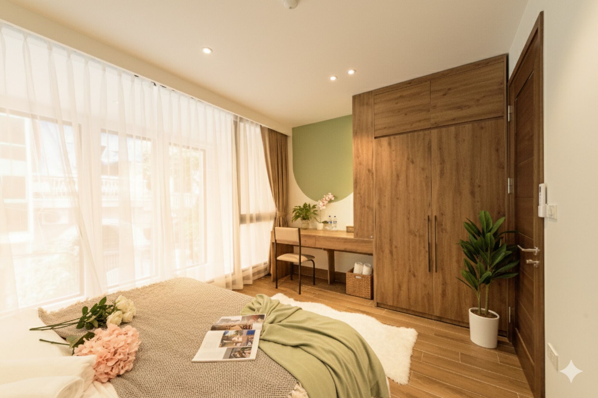 A bedroom with a bed, a desk, a wardrobe, and a potted plant.