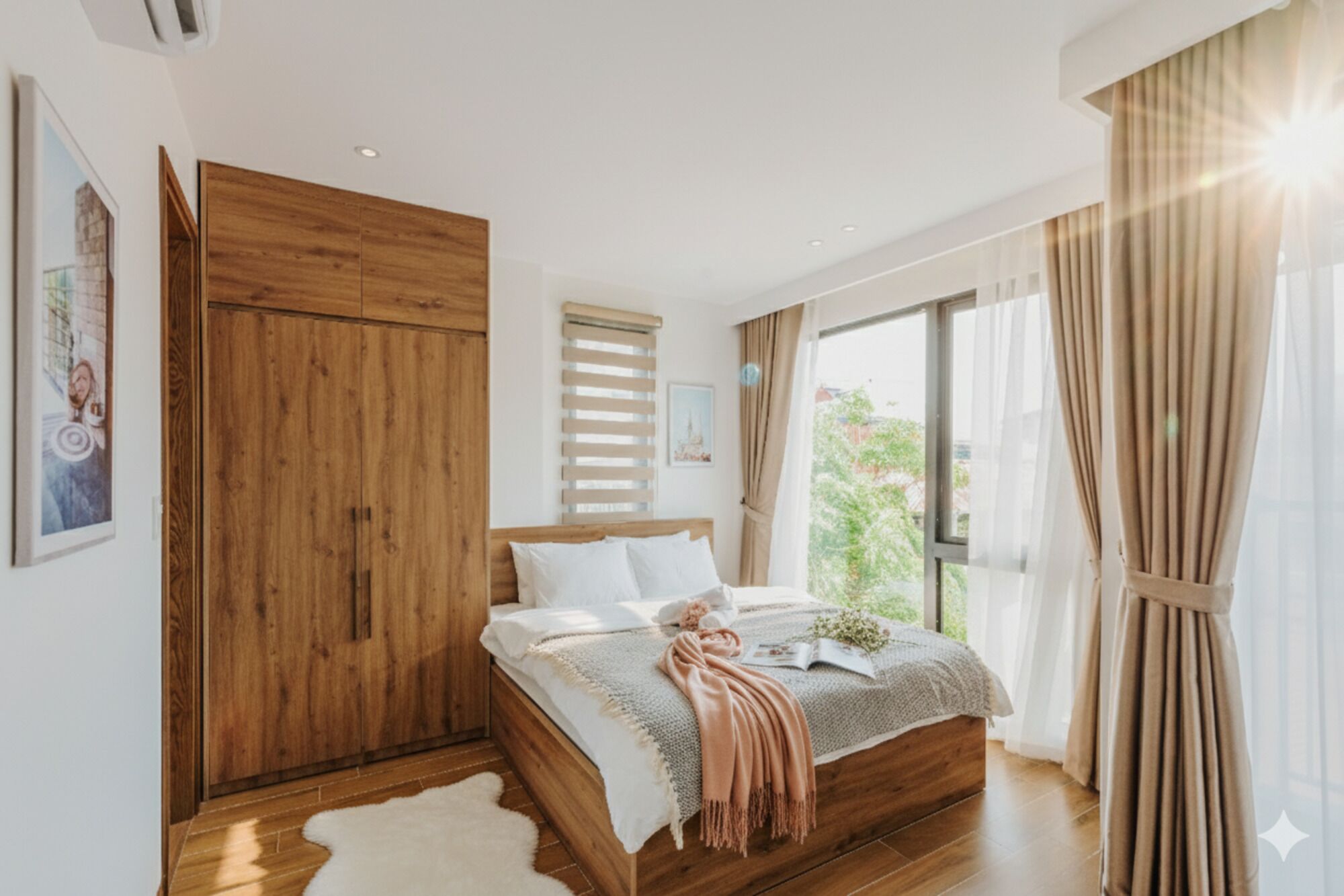 A bedroom with a wooden wardrobe, a bed with a beige blanket, and a large window with curtains.