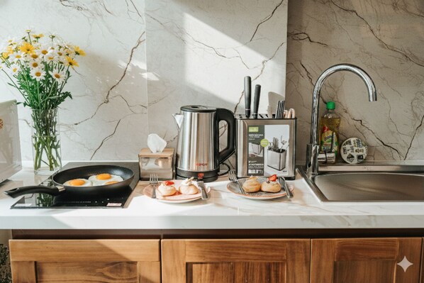 Estúdio júnior, vista para o pátio | Cozinha privada | Geladeira grande, cooktop, talheres/pratos/utensílios de cozinha