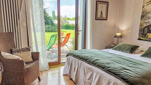A bedroom with a bed, a chair, a table, and a view of the outdoors. - La Roche Blanche by Interhome (Hillion)