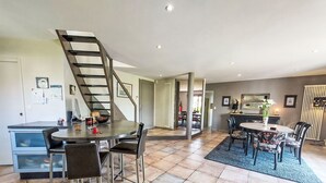 A modern kitchen with a built-in oven and a dining area with a round table and chairs. - La Roche Blanche by Interhome (Hillion)