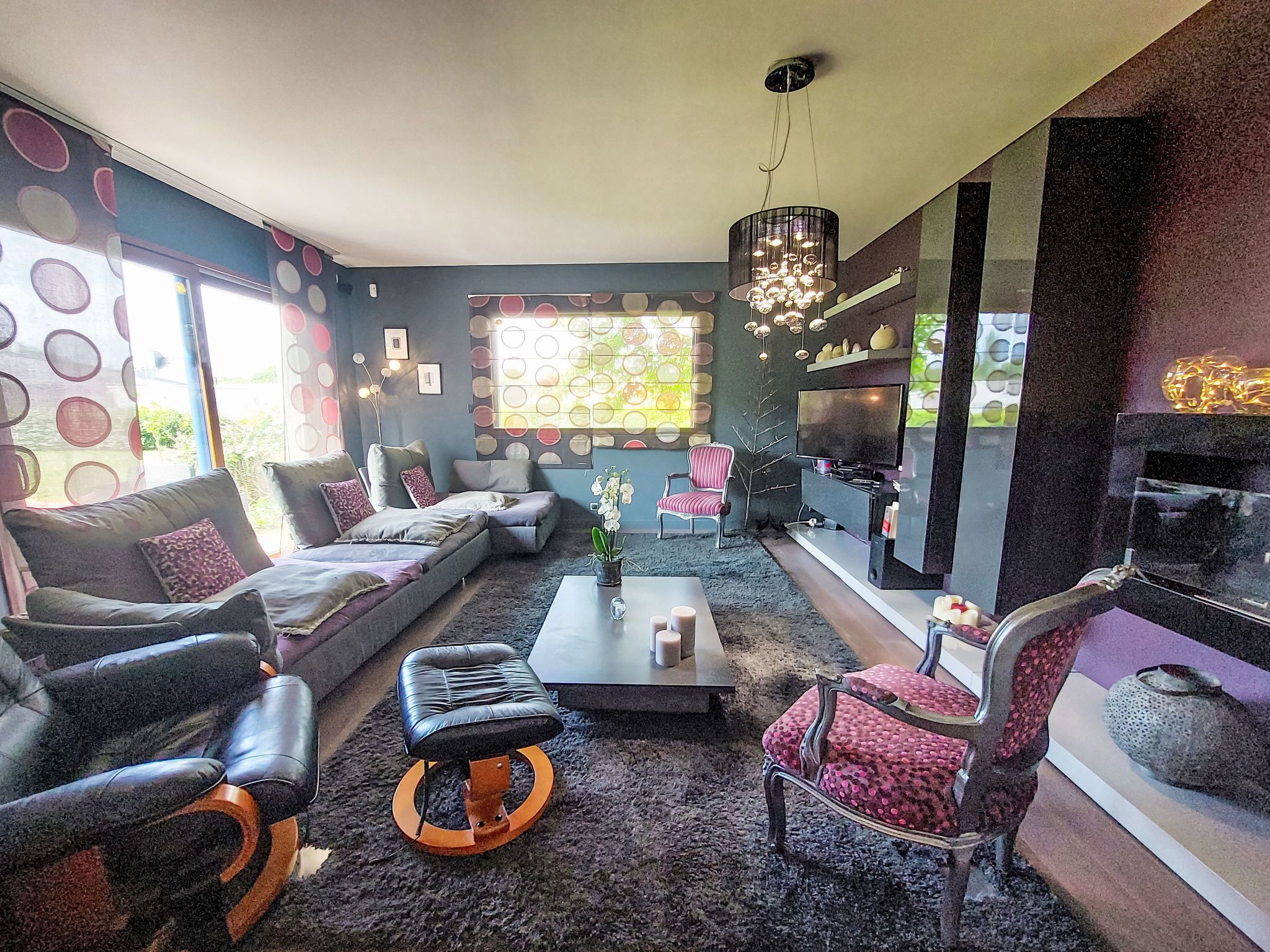 Uma sala de estar moderna com um sofá seccional, uma mesa de centro e uma televisão.