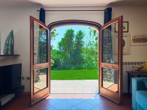 An open door leading to a garden with a lawn and trees. - Casa delle Chicche - Imperia (Imperia)