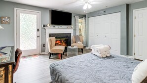 A bedroom with a fireplace, a bed, a TV, and a ceiling fan. - 1 Mi to Boardwalk: Convenient North Beach Apt! (North Beach)