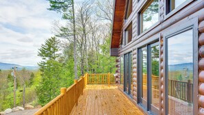 A wooden deck with a railing, large windows, and a view of a forested area. - Mtn-View Deck: Scenic Conway Log Cabin! (Conway)