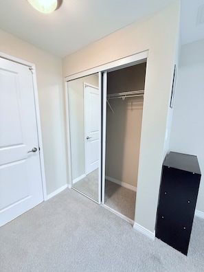 A room with a closet, a door, and a black object on the floor.