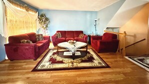 Una sala de estar con dos sofás rojos, una mesa de centro y un tapete estampado.