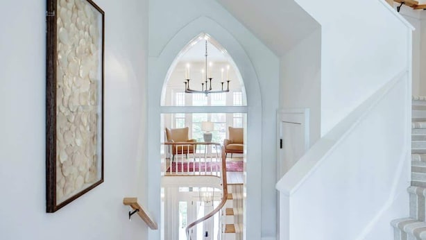 Eine Treppe führt zu einem Balkon im zweiten Stock mit Blick ins Freie.