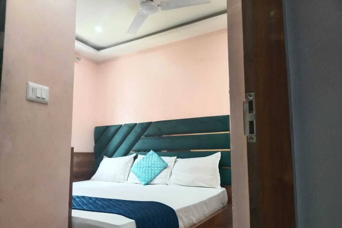 Un dormitorio con cama, ventilador de techo y una puerta.