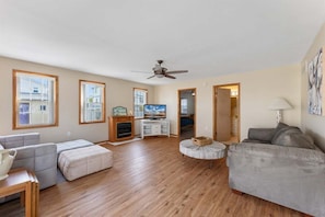 A spacious living room with a ceiling fan, a fireplace, a television, and a sofa. - 4 Bedroom Single-Family Home in North Wildwood (North Wildwood)