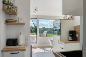 A modern kitchen with a toaster, coffee maker, and a view of the outdoors.